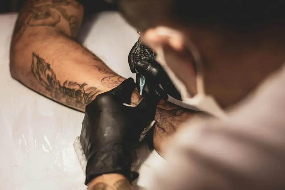 Tatuador trabajando un antebrazo